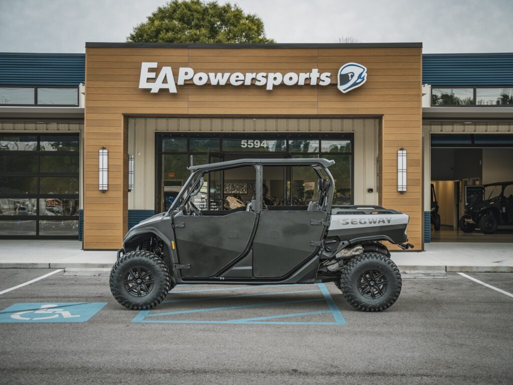 Black Segway off-road utility vehicle parked in a handicap space in front of the EA Powersports store storefront.