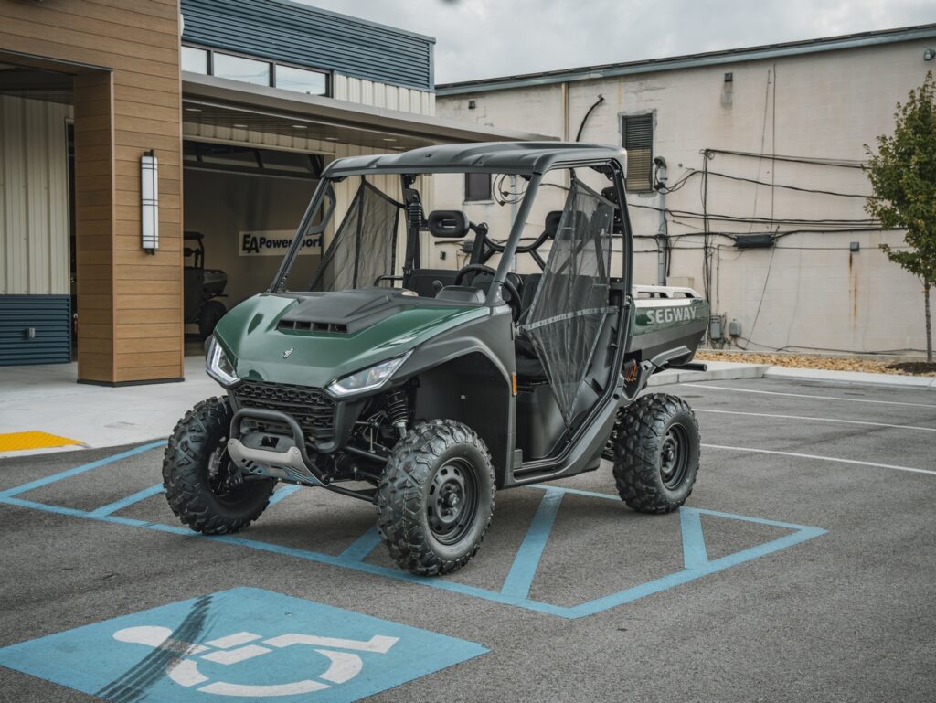 Green and black off-road utility vehicle (UTV) with roll cage parked in a handicapped parking space in front of a commercial building.
